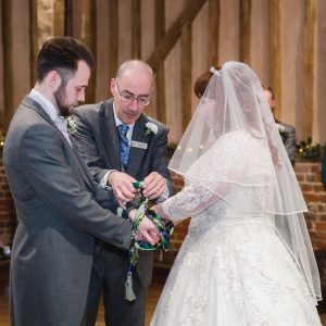 Civil celebrant handfasting a wedding couple