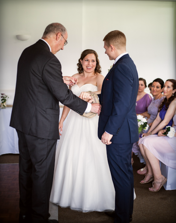 Civil celebrant handfasting couple at wedding